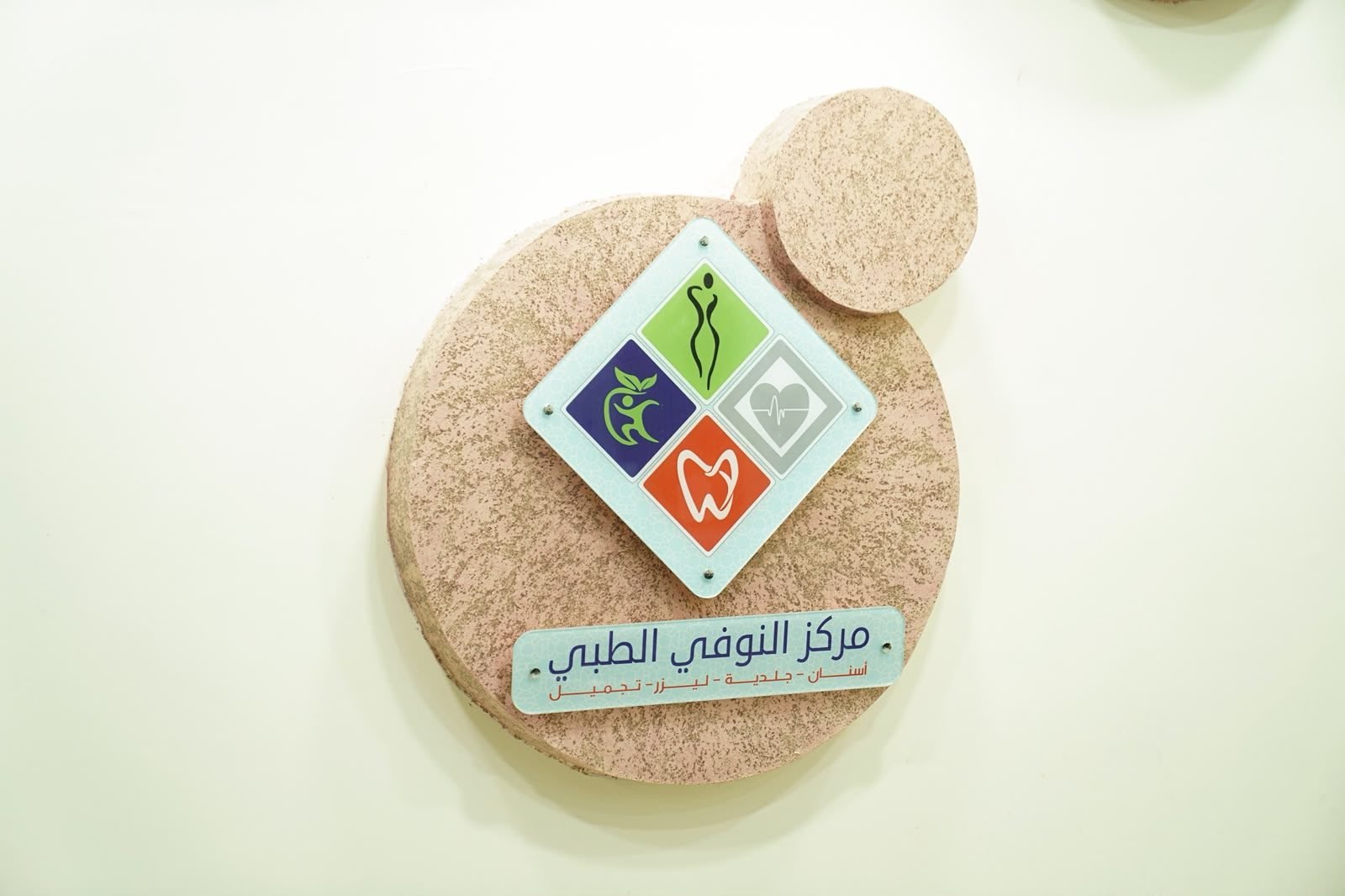 شعار مركز النوفي الطبي: أسنان جلدية ليزر تجميل